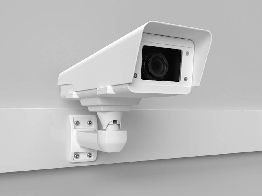 a white security camera mounted on a wall