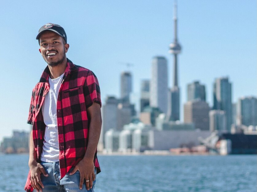 standing man taking selfie beside cn tower canada