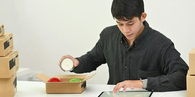 young man online small business owner packing drop product on box FEATURED IMAGE