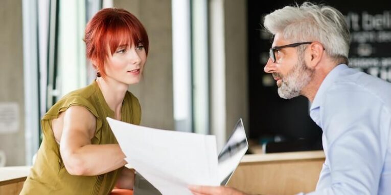 two business people in workplace woman and man in creative office consulting a project together FEATURE IMAGE