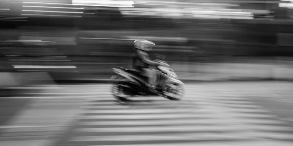a blurry photo of a person riding a motorcycle FEATURED IMAGE