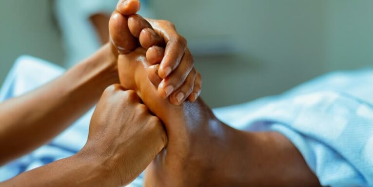 a person laying in a bed with their feet up FEATURED IMAGE