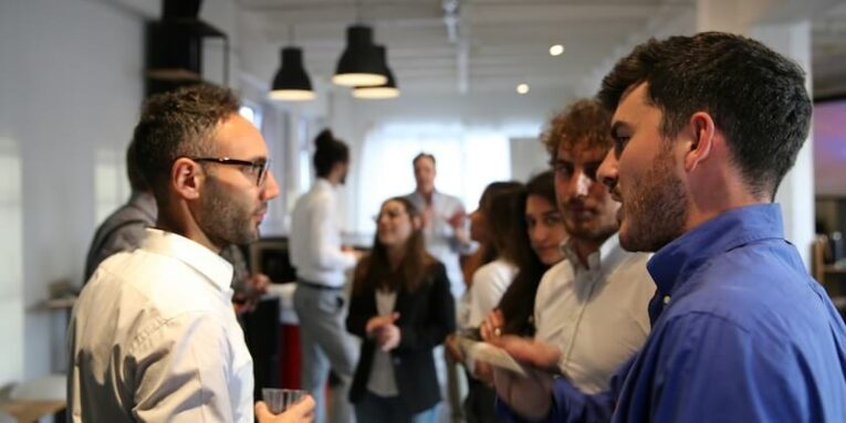 a group of people standing in a room FEATURED IMAGE