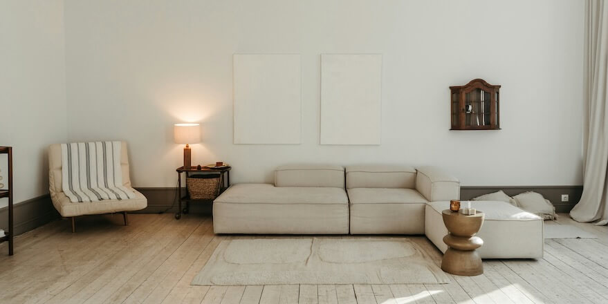a living room with a white couch and a white chair FEATURED IMAGE