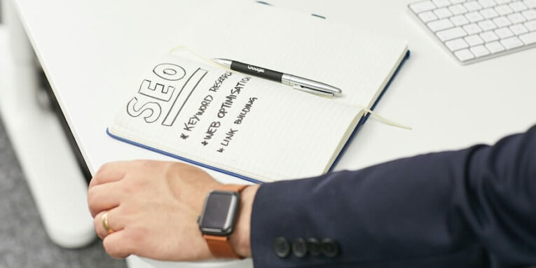a person writing on a piece of paper FEATURED IMAGE