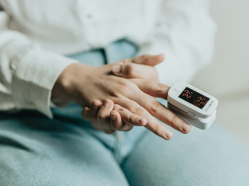 a person sitting on a couch holding an electronic device