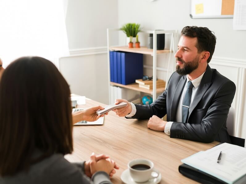 finance agent giving money to his clients financial advisor giving a loan to a couple to buy a new house