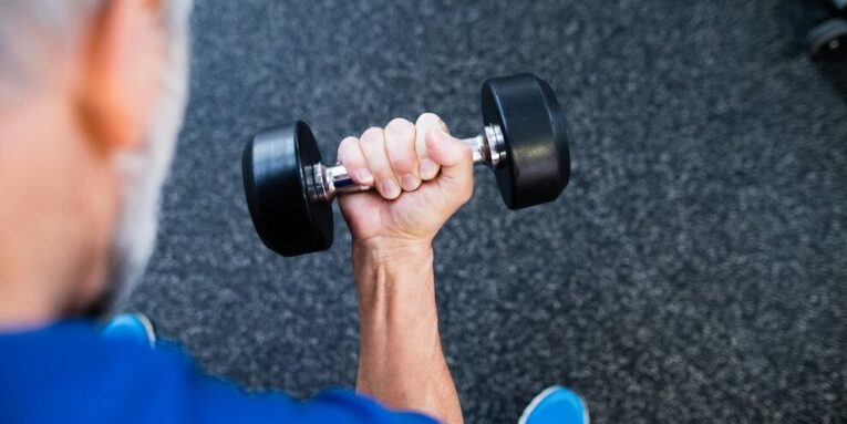 unrecognizable senior man in sports clothing in gym working out with weights FEATURED IMAGE