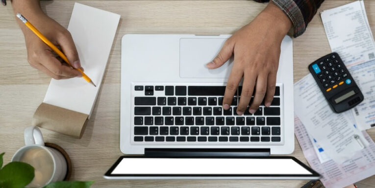 overhead view man calculating and managing household finances at home FEATURED IMAGE