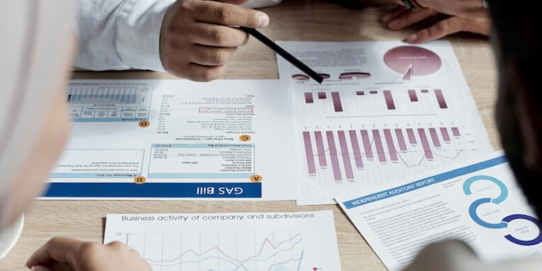 group of financial specialists sitting at table and analyzing reports while making profit forecast FEATURED IMAGE