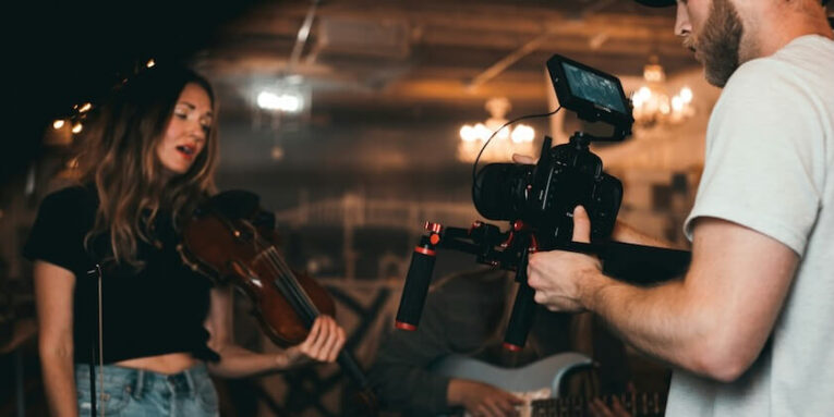 man taking video of woman holding violin FEATURED IMAGE
