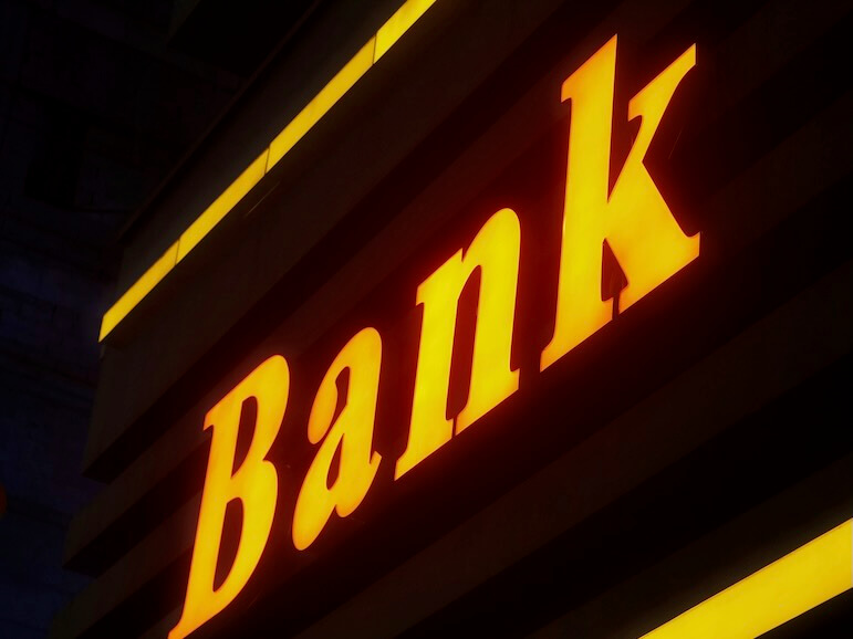 a bank sign lit up in the dark