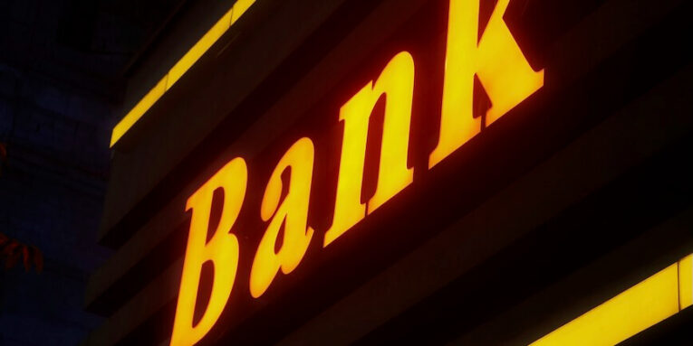 a bank sign lit up in the dark FEATURED IMAGE