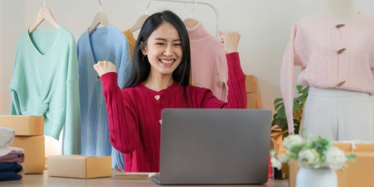 a woman sitting at a desk in front of a laptop computer FEATURE IMAGE