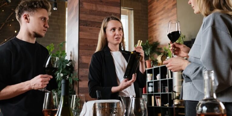 a group of people standing around a table with wine glasses FEATURED IMAGE