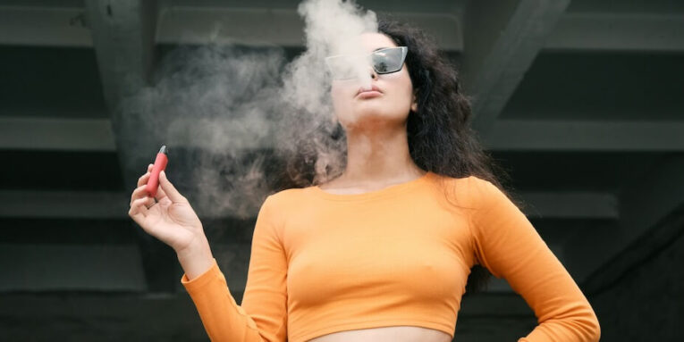 a woman vaping in a yellow top FEATURED IMAGE