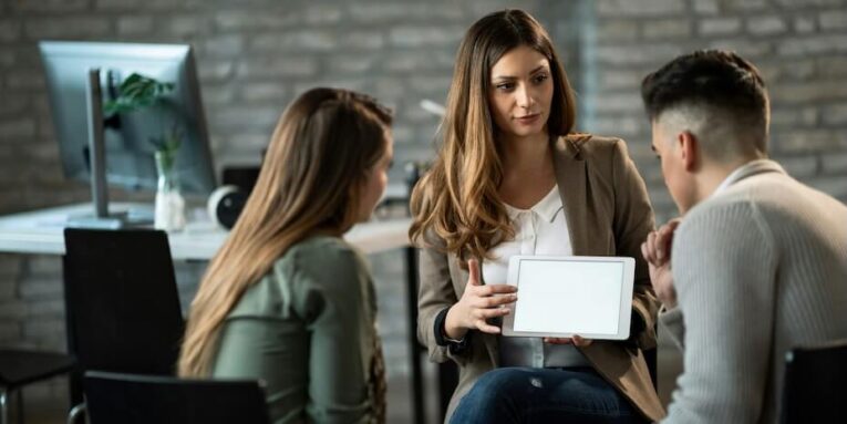 financial advisor having a meeting with young couple and showing them their investment plans on touchpad copy space FEATURED IMAGE