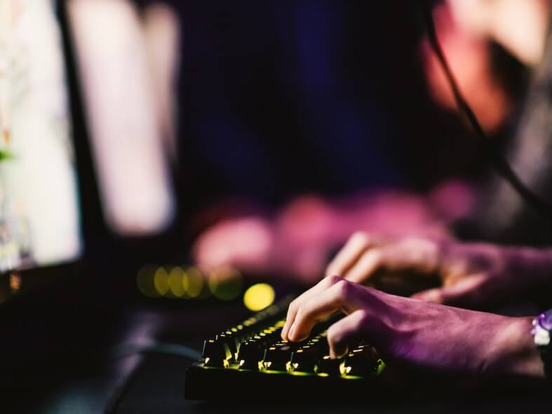 close up of hands using keyboard for game at gaming room