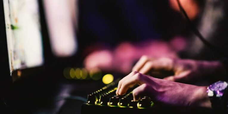 close up of hands using keyboard for game at gaming room FEATURED IMAGE