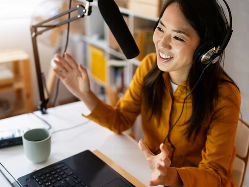 modern female entrepreneur japanese ethnicity talking about some topics on her podcast radio from her home office