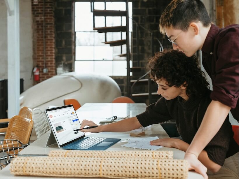 a teen and a woman are looking at a laptop