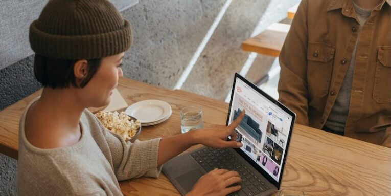 two people sitting across from each other in an office working on a surface laptop FEATURED IMAGE