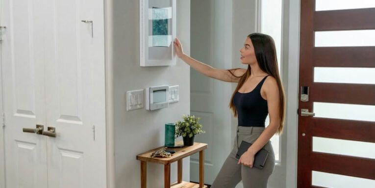 a woman standing in front of a wall mounted light switch FEATURED IMAGE