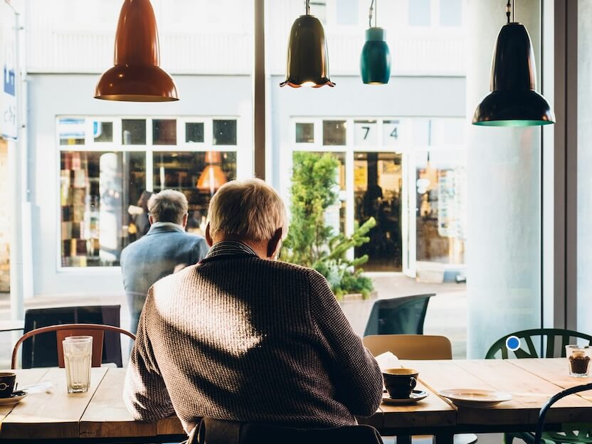 man in chair with table beside coffee