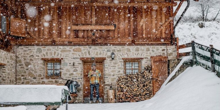 a man standing in front of a building in the snow FEATURED IMAGE