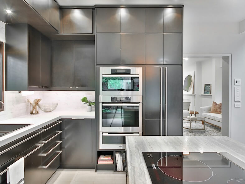 a modern kitchen with stainless steel appliances and marble counter tops