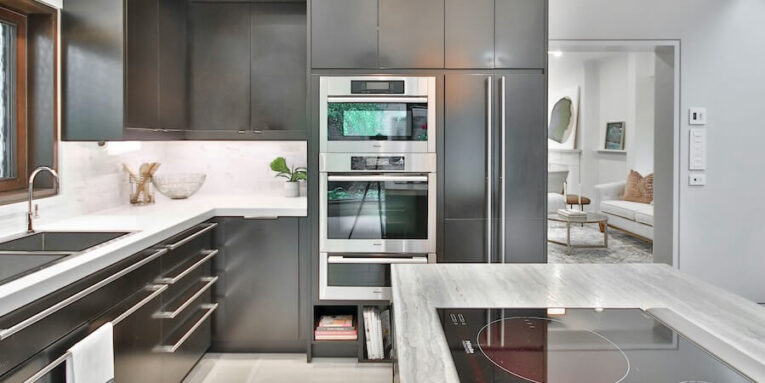 a modern kitchen with stainless steel appliances and marble counter tops FEATURED IMAGE