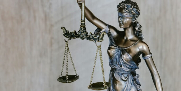 woman holding sword statue during daytime FEATURED IMAGE