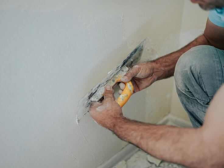 a skilled plasterer working on a wall