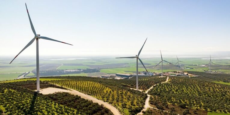 a wind farm with several windmills in the background FEATURED IMAGE