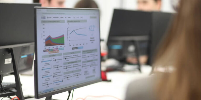 a group of people working on computers in a room FEATURED IMAGE