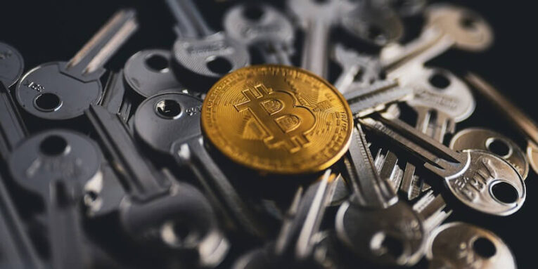 a pile of keys with a bitcoin on top of them FEATURED IMAGE
