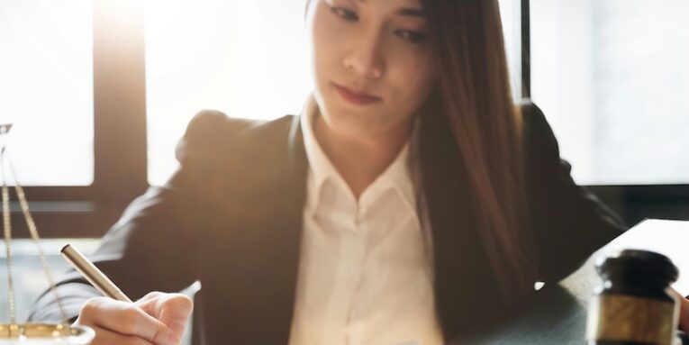 judge gavel with justice lawyers business woman in suit or lawyer working on a documents legal law advice and justice concept FEATURED IMAGE
