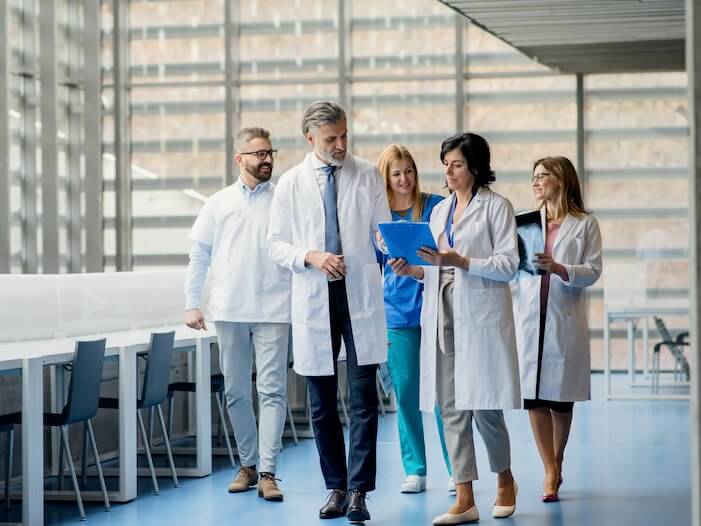 group of doctors walking in corridor on medical conference talking