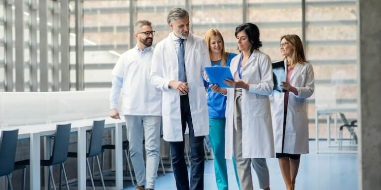 group of doctors walking in corridor on medical conference talking