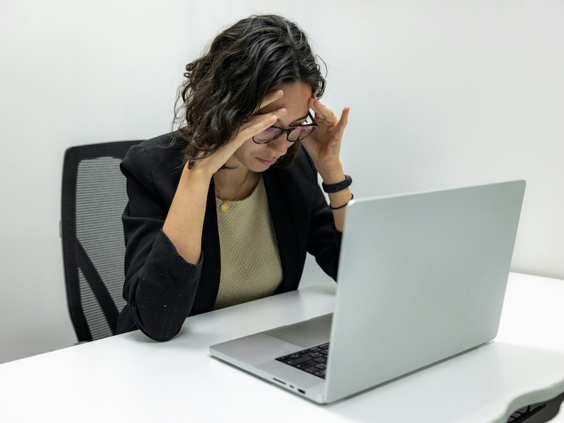 a woman sitting in front of a laptop computer