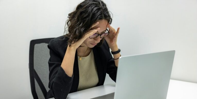 a woman sitting in front of a laptop computer FEATURED IMAGE