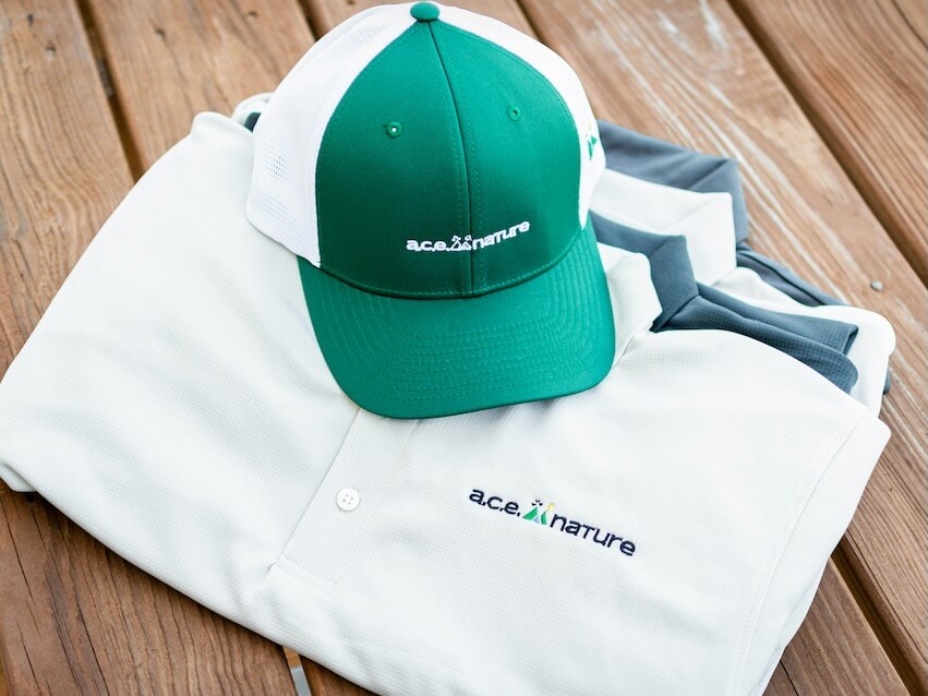 a green and white hat sitting on top of a white shirt