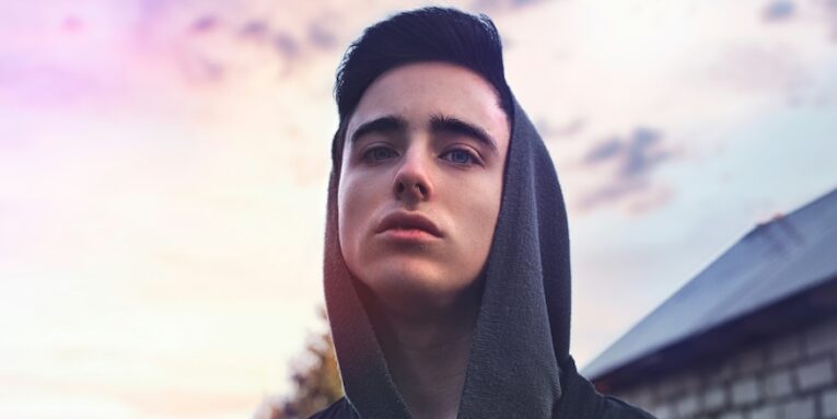 a teen in a hoodie looking up at the sky FEATURE IMAGE