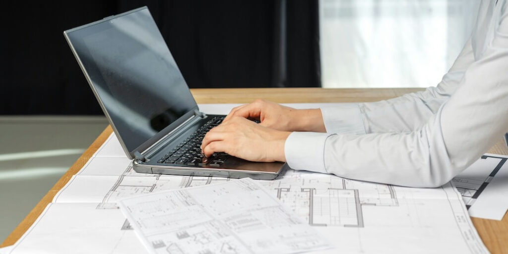 lady in her formal wear sitting at the desk in bright loft interior work at pc gadget FEATURED IMAGE