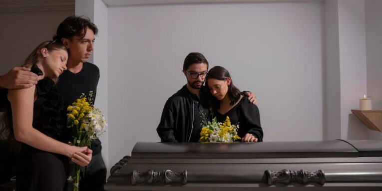 a man and a woman looking at a casket FEATURE IMAGE