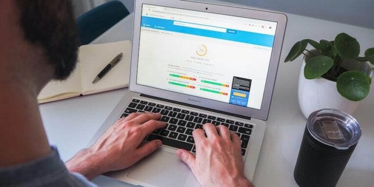 person using MacBook pro on white table FEATURED IMAGE