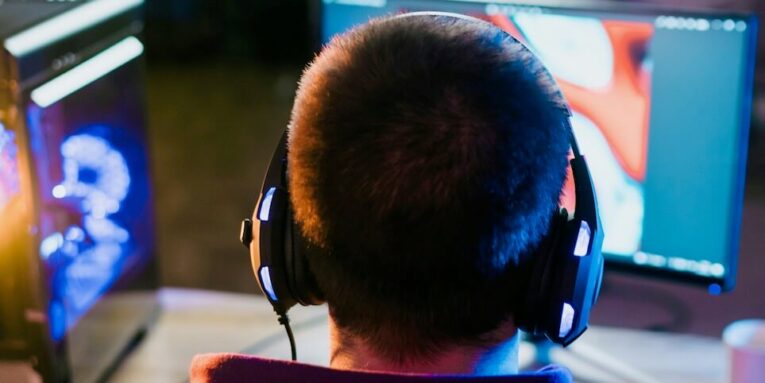 a man wearing headphones sitting in front of a computer FEATURED IMAGE