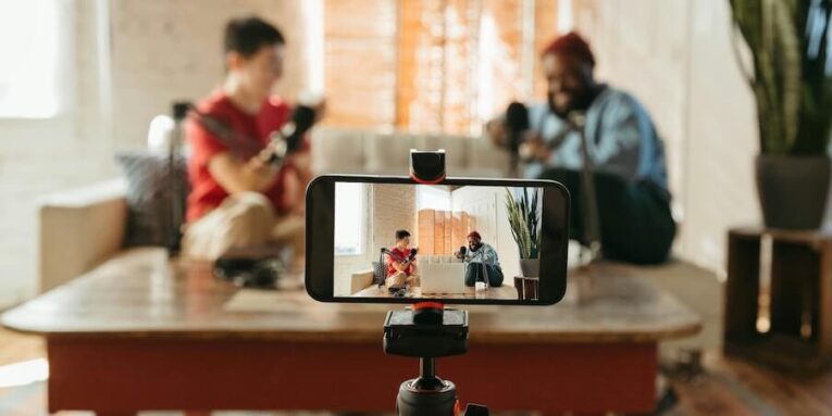 a person taking a picture of two people sitting on a couch FEATURED IMAGE