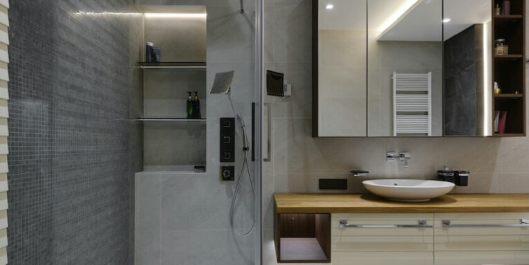 a bathroom with a sink mirror and shower stall FEATURED IMAGE