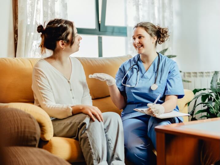 two women sitting on a couch talking to each other